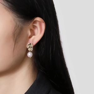 Vintage Baroque pearl drop earrings with irregular gold textured metal worn by model
