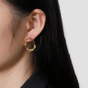 Elegant gold earrings with irregular melted metal texture and organic streamlined design