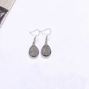 Vue macro détaillée de boucles d'oreilles goutte d'argent avec texture de cristal druzy gris