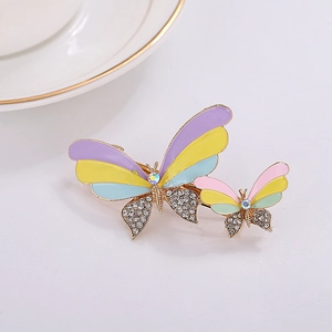 Detailed macro view of colorful enamel butterfly hair clip with sparkling rhinestones