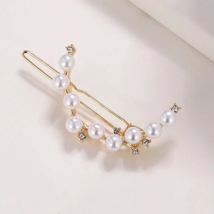 Detail of gold-plated crescent hair clip featuring elegant pearls and sparkling rhinestones