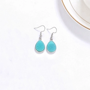 Vue détaillée des boucles d'oreilles gouttes en résine turquoise avec crochets argentés