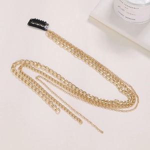 Detailed view of elegant gold multi-layer chain hair accessory with a black BB clip fastener