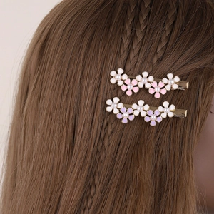 Fermagli per capelli a fiore con petali smaltati e perle su capelli scuri