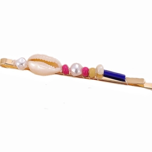 Detailed close-up of shell hair clip with colorful beads on a gold plated base