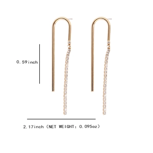 Détail macro de boucles d'oreilles longues dorées à glands et cristaux brillants