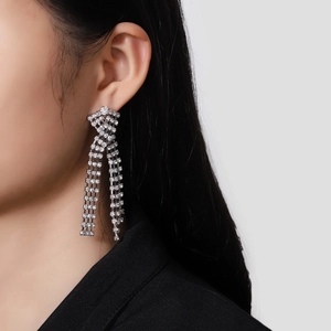 Boucles d'oreilles longues à pompons argentés avec strass étincelants style croisé