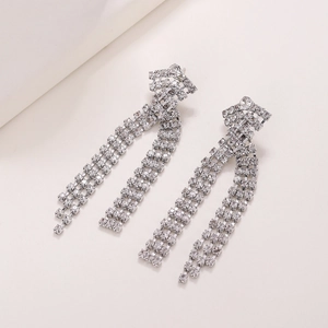 Élégantes boucles d'oreilles pompon argentées avec de longues chaînes en strass étincelants