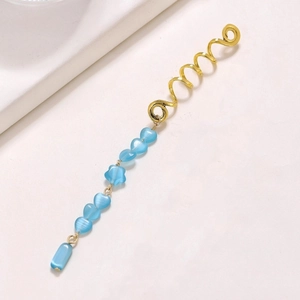 Detail of gold spiral hair ring with blue beaded charms in heart and star shapes