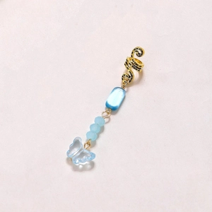 Detail of snake-style hair accessory with blue crystal beads and butterfly pendant