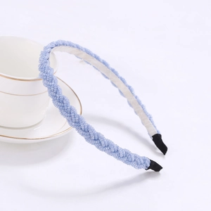 Close-up of light blue beaded headband with intricate woven texture and black fabric ends
