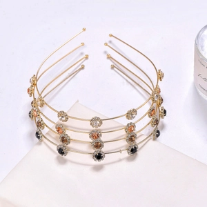 Close-up of four-layer gold floral headband with white, amber, and black crystals