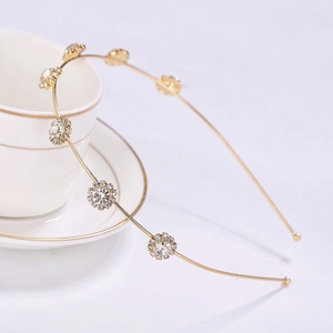 Close-up of golden sunflower headband with sparkling rhinestones on a coffee cup