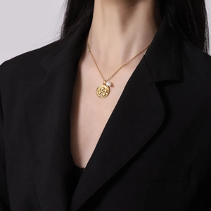 Collier vintage doré avec pendentif trèfle et perle naturelle porté par un mannequin