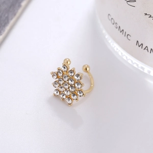 Dettaglio macro di un earcuff a fiocco di neve dorato con zirconi per orecchie senza buco
