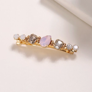 Détail de strass rose en goutte d'eau et perles à la main sur une pince à cheveux dorée
