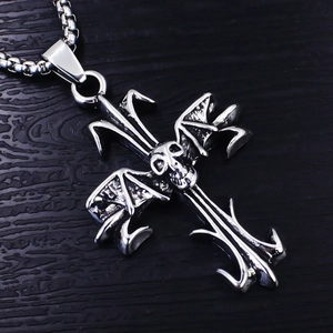 Macro shot of gothic cross necklace with skull and bat wing details in vintage silver