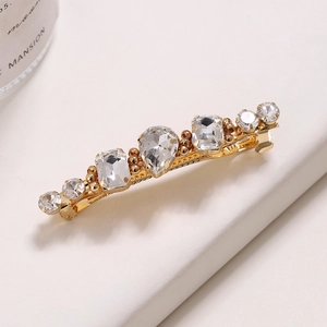 Détail macro de la barrette à strass étincelants avec cristal en goutte sur base dorée
