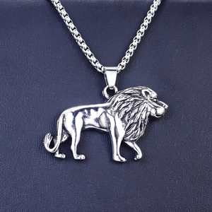 Détail d'un pendentif lion argenté avec textures musculaires et une chaîne maille vénitienne