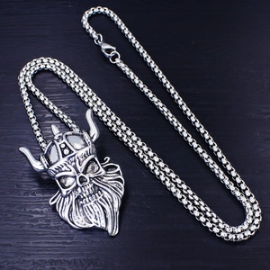 Collana con ciondolo teschio vichingo retrò in acciaio inox su sfondo di legno nero
