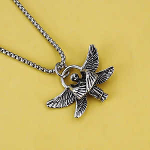 Vintage silver angel wing pendant necklace in stainless steel on yellow background