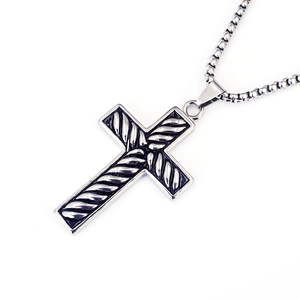 Detail of cross pendant with rope texture inlay and box chain on white background