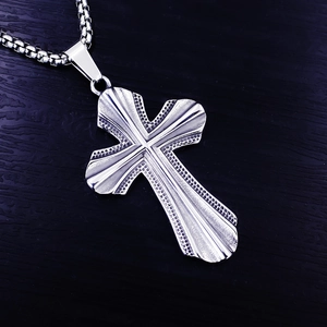 Gros plan du pendentif croix punk en acier inoxydable avec texture gravée de points précis
