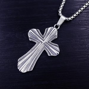 Détail du pendentif croix argenté avec rainures texturées et chaîne box carrée