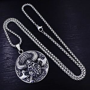 Collana vichinga vintage con teschio e asce incrociate su sfondo in legno nero