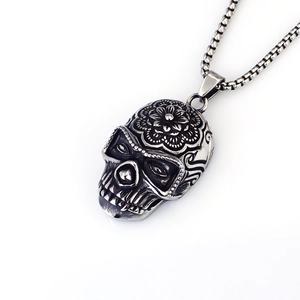 Détail du pendentif crâne gothique vintage gravé avec une chaîne maille carrée robuste