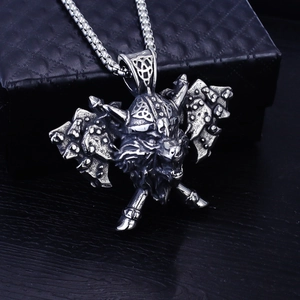 Detail of Viking wolf head pendant with axe and helmet on dark leather display