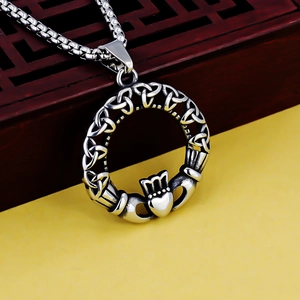 Poliertes Edelstahl-Claddagh-Halskette mit Keltenknoten-Anhänger auf gelbem Grund