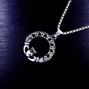 Makrodetail des Claddagh-Anhängers mit keltischen Knotenmustern an einer Edelstahl-Boxkette