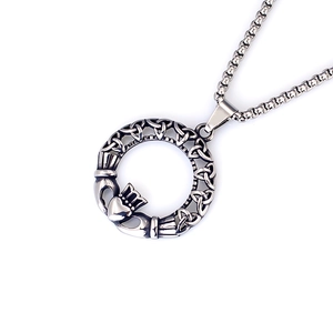 Detail eines Vintage-Claddagh-Anhängers aus Edelstahl mit keltischem Knoten und Perlenkette