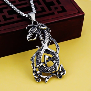 Detailed close-up of a silver Viking dragon pendant with intricate Celtic knot engraving