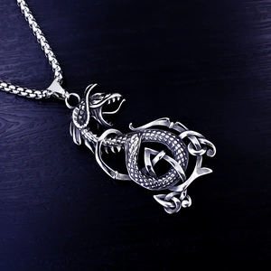 Macro view of vintage silver dragon pendant featuring intricate Celtic knot metalwork details