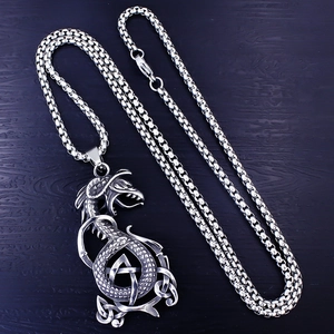 Vintage stainless steel dragon necklace with Celtic knot pendant on dark wood background