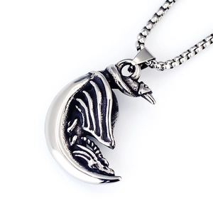 Detailed view of a vintage stainless steel dragon and crescent moon pendant on a box chain