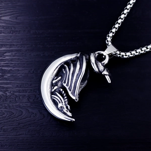 Detailed view of vintage stainless steel crescent moon pendant with a dragon design