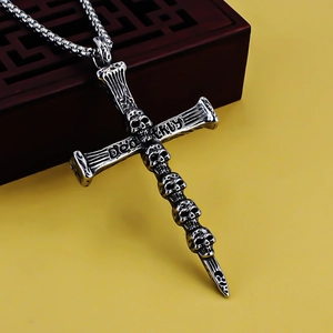 Macro shot of silver gothic cross pendant with skull carvings and antique metal finish