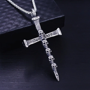Detail of gothic cross pendant with stacked skulls and Deathly engraving on chain