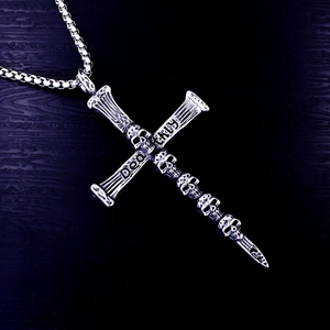 Macro shot of gothic cross pendant with skull details and vintage oxidized steel finish