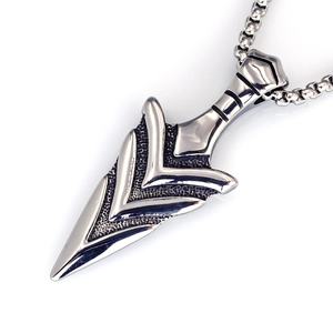 Close-up of vintage stainless steel arrowhead pendant with textured finish and metal beads