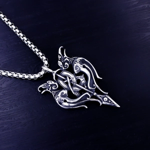 Détail du pendentif épée viking avec gravures de dragon sur fond de bois sombre