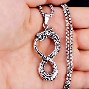 Gros plan d'un pendentif dragon en acier inoxydable vintage avec des écailles détaillées