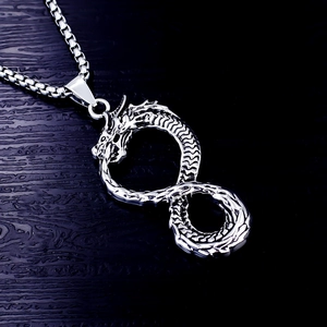 Détail du pendentif dragon viking infini vintage sur une surface en bois noir