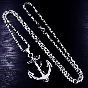 Polished silver anchor pendant necklace with cross detail on dark wooden texture