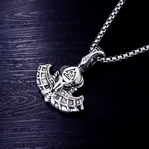Detailed view of Viking axe pendant with Valknut symbol and Nordic patterns on wood
