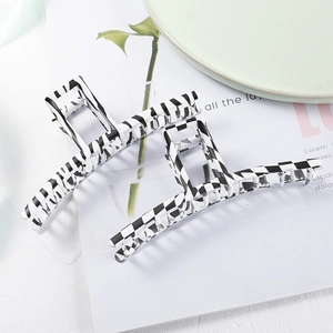Detail view of large leopard and checkerboard pattern hair claws on a magazine