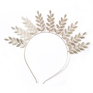 Detailed close-up of a light gold laurel leaf headband with a polished metallic finish